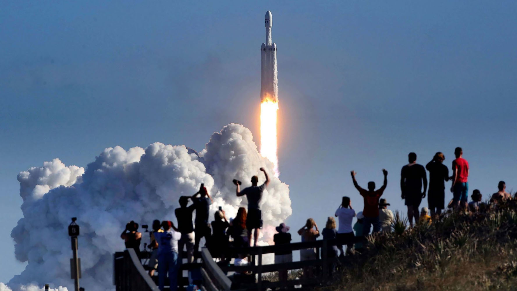 La foule applaudit à Playalinda Beach sur le Canaveral National Seashore, juste au nord du Kennedy Space Center, lors du lancement de la fusée SpaceX Falcon Heavy, le 6 février 2018. Playalinda est l'un des points de visionnement public les plus proches pour voir le lancement, à environ 3 miles de la rampe de lancement SpaceX 39-A.  (Joe Burbank/Orlando Sentinel/Tribune News Service via Getty Images)